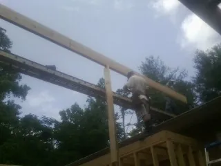 Carpenter setting a ridge beam over a new addition frame — Ice Dam Removal by Roofing Brothers in Paxico