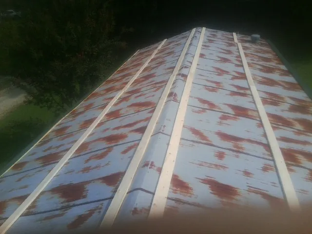 Rusted metal roof panels with new wood purlins before replacement — Storm Damage Roof Repair in Paxico by Roofing Brothers