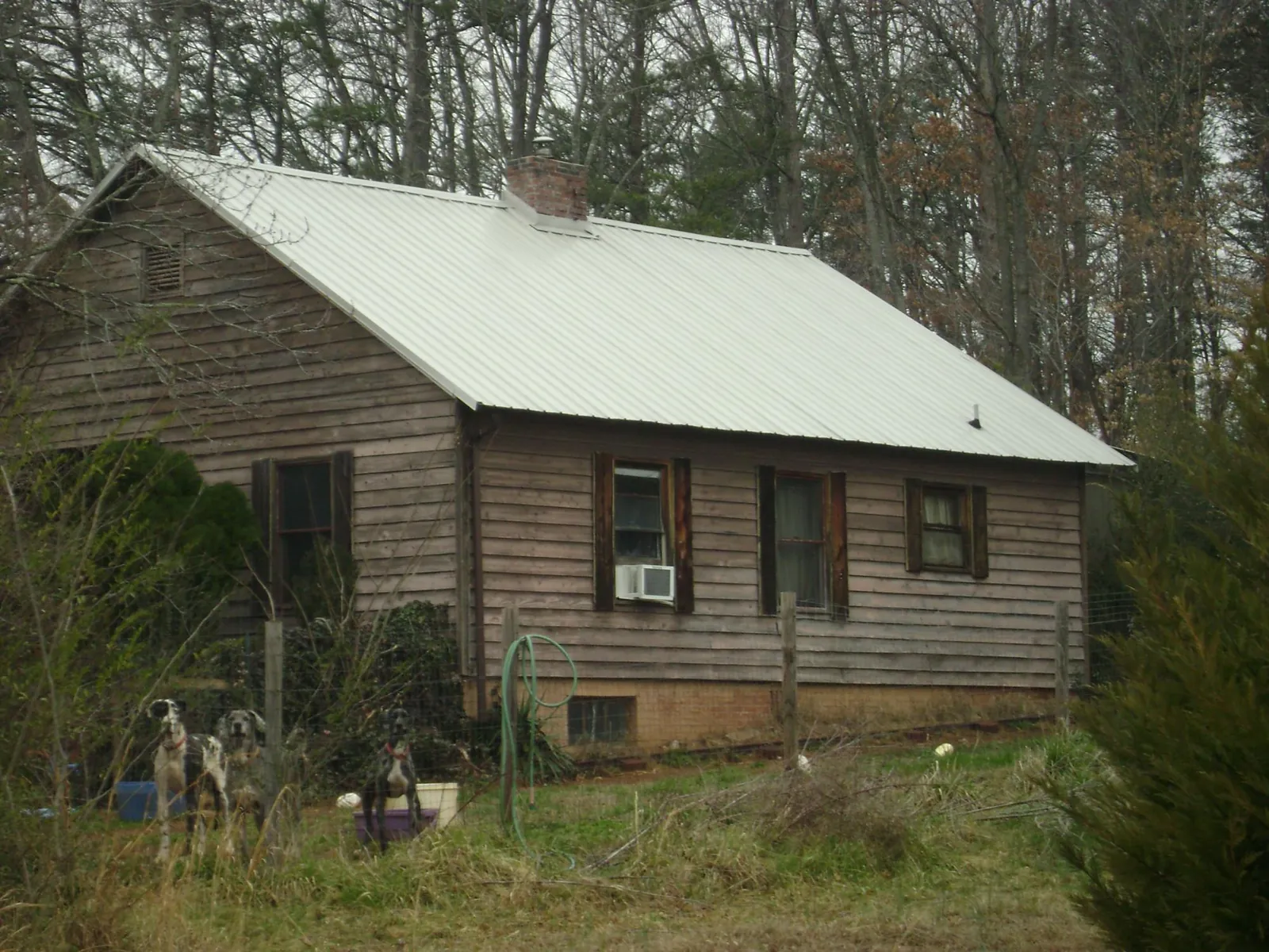 White metal roof on an old wood sided farmhouse, from a Metal Roof Installation job in Paxico